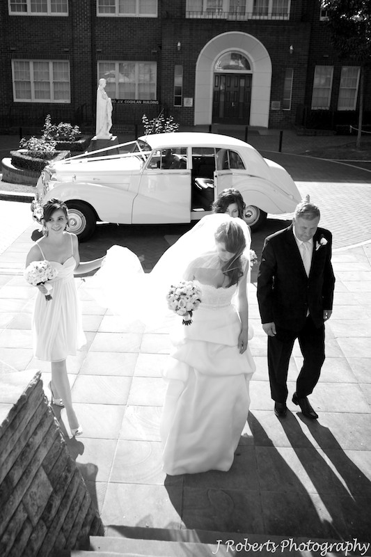 Bride arriving at the church being helped by bridesmaids - wedding photography sydney